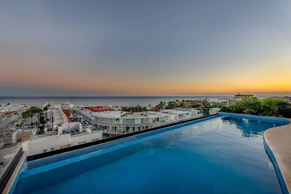 Rooftop pool with sun loungers and panoramic sea views; relax under the blue sky