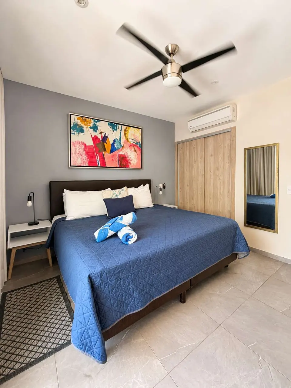 Rest in a calm and comfortable bedroom with a king-size bed, air conditioning, and ceiling fan — designed to help you unwind after enjoying Playa del Carmen.