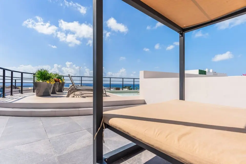 Relax and unwind under the shade on a daybed. Ocean views included!